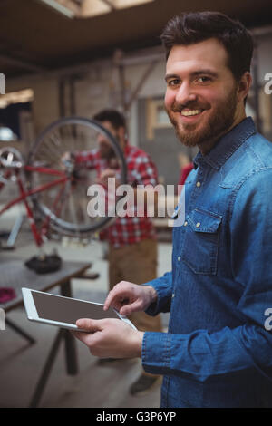 Portrait of man mechanic smiling and using a tablet computer Stock Photo