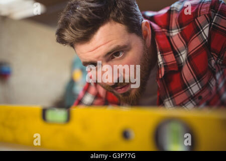 Carpenter using spirit level to measure Stock Photo