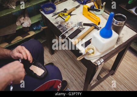 Cobbler using a tool on a shoe Stock Photo