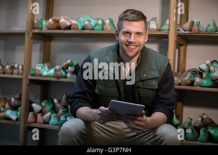 Cobbler holding digital tablet Stock Photo