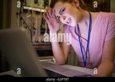 Stressed technician working on laptop Stock Photo
