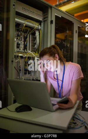 Stressed technician working on laptop Stock Photo