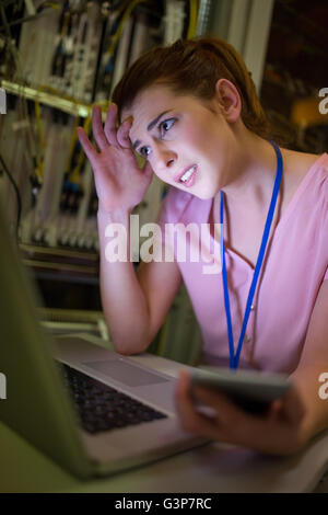 Stressed technician working on laptop Stock Photo