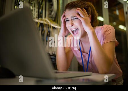 Stressed technician working on laptop Stock Photo