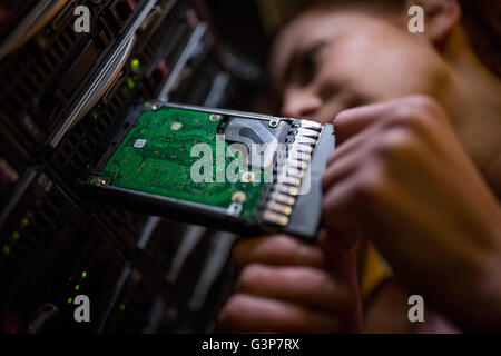 Technician inserting a hard disk drive into a blade server Stock Photo