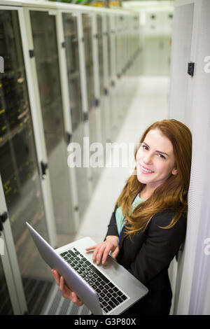 Technician using laptop in server room Stock Photo