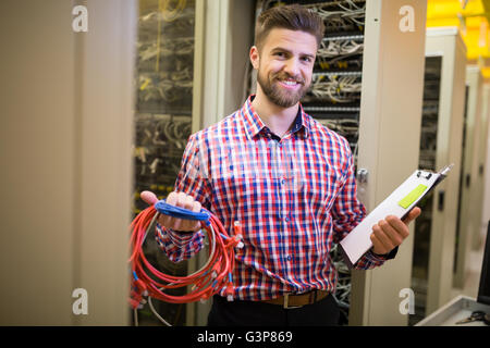 Technician holding patch cable and clipboard Stock Photo