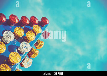 Vintage toned background made of colorful light bulbs close up in an amusement park, shallow depth of field. Stock Photo