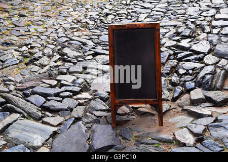 Empty chalkboard or blackboard on the street with copyspace. Blank menu board with space for text. Stock Photo