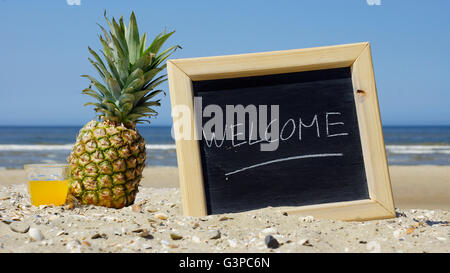 Welcome written on a chalkboard at the beach Stock Photo