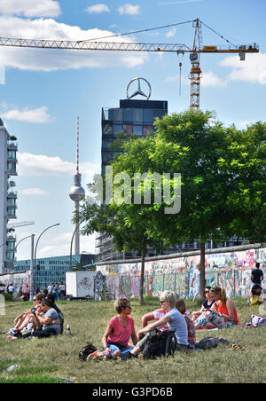 Mercedes Sign TV Tower Television by the East Side Gallery's murals graffiti street art on the 1.3km section of the German Berlin Wall by the river Spree and  Muhlenstrasse ) Friedrichshain Spree wall former border Kreuzberg Germany Stock Photo