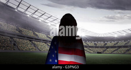 Composite image of rear view of sporty woman holding an american flag Stock Photo