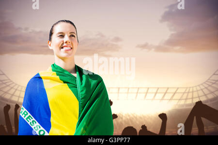 Composite image of sporty woman holding brazilian flag Stock Photo