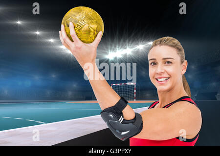 Composite image of female athlete with elbow pad holding handball Stock Photo