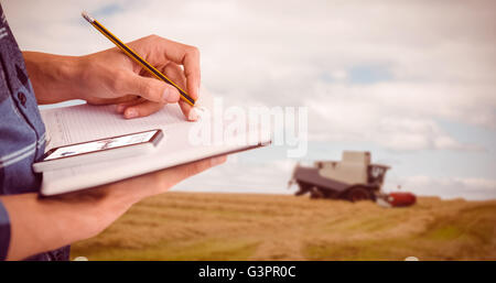 Composite image of cropped image of businessman writing with pencil on book Stock Photo