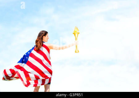 Composite image of rear view of american sportswoman holding a cup Stock Photo