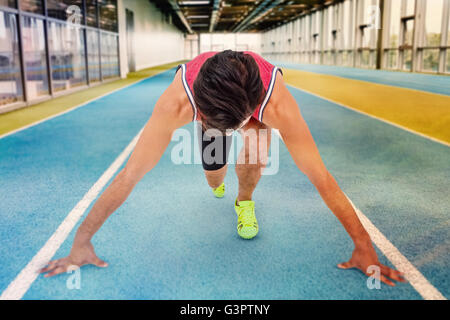 Composite image of male athlete in ready to run position Stock Photo