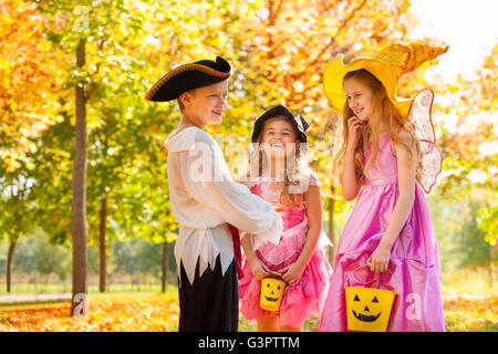 Laughing children in Halloween costumes together Stock Photo