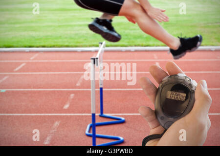 Composite image of coach is holding a stopwatch Stock Photo