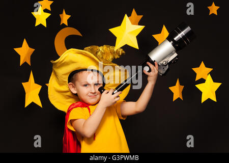 Little sky watcher looking through a telescope Stock Photo