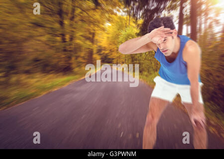 Tired athlete wiping his sweat with hand Stock Photo