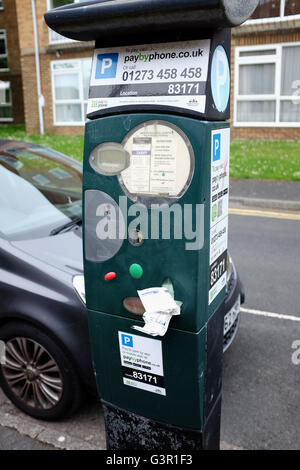 Broken parking meter in city of Brighton printing out useless tickets with frustrated female motorist UK Stock Photo