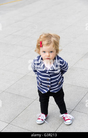 One year old toddler standing up outdoors, England, UK Stock Photo