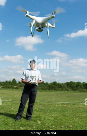 Man flying DJI Phantom 4 quadcopter drone in park, England, UK Stock Photo
