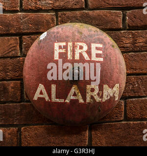 Vintage Fire Alarm Bell Against A Red Brick Wall Stock Photo