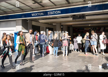 People waiting and British-African couple walking in front of the entrance of Brixton Underground station in South London Stock Photo