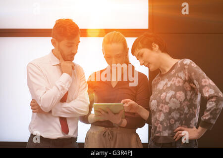 young startup business people group, brainstorming and working on tablet computer sunflare and sunrise in background Stock Photo