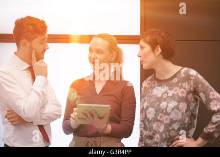young startup business people group, brainstorming and working on tablet computer sunflare and sunrise in background Stock Photo