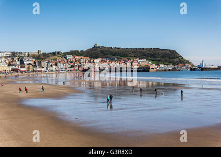 People enjoying a bright, sunny, spring day on Scarborough's south bay beach Stock Photo