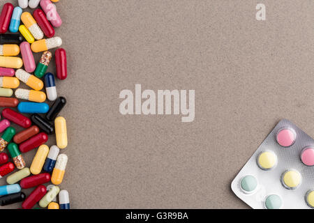 Various colorful capsules and pills on brown craft paper Stock Photo