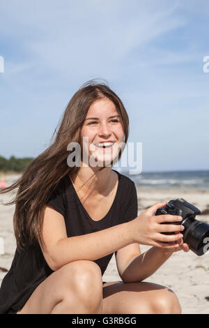 Sweden, Skane, Ahus, Teenage girl (16-17) taking pictures on beach