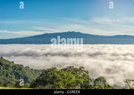 Barva volcano and near mountain ranges in the central valley of Costa Rica seen above the clouds Stock Photo