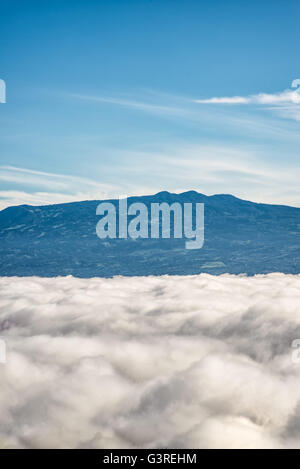 Barva volcano and near mountain ranges in the central valley of Costa Rica seen above the clouds Stock Photo