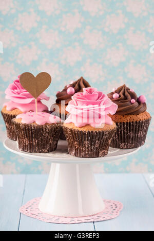 Cupcakes with sweet rose flowers and a cakepick for text Stock Photo
