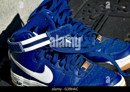 A pair of blue Nike shoes sitting on a door mat in front of a house Stock Photo