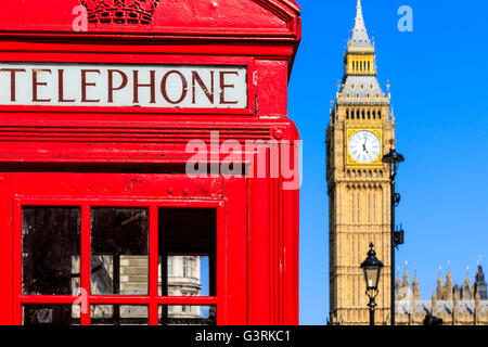 Iconic red telephone box with Big Ben against blue sky in the background Stock Photo