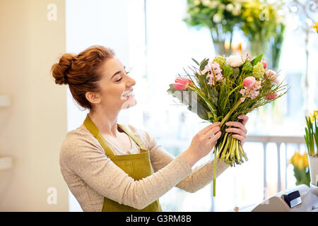 smiling florist woman making bunch at flower shop Stock Photo