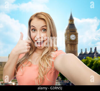 happy woman taking selfie and showing thumbs up Stock Photo