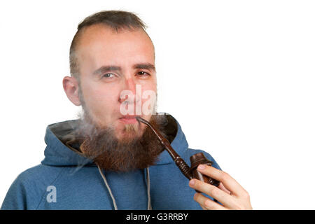 young bearded guy smoking a pipe on a light background Stock Photo