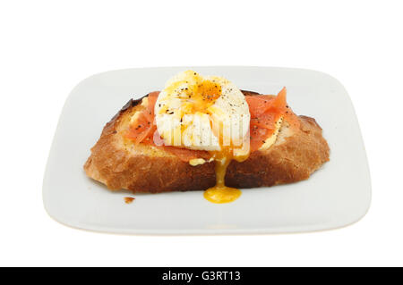 Poached egg and smoked salmon on toasted crusty bread on a plate isolated against white Stock Photo