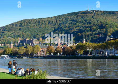 River Neckar , sunbathers on the Neckar meadows and overlooking the old town with its castle and mountain Königstuhl, Germany, B Stock Photo