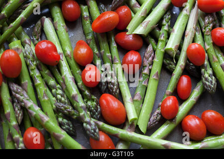 Asparagus and baby plum tomatoes in olive oil Stock Photo