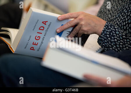 Dresden, Germany. 14th June, 2016. A journalist holding a book during the presentation of the book 'Pegida. Warnsignale aus Dresden' (lit. 'Pegida. Warning signs from Dresden') in Dresden, Germany, 14 June 2016. PHOTO: ARNO BURGI/dpa/Alamy Live News