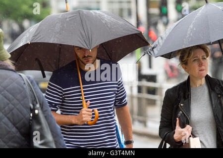 Wimbledon London, UK. 14th June 2016. Pedestrians shelter under umbrellas as the met office predicts more rains to come over the next days and a wet June forecast Credit:  amer ghazzal/Alamy Live News Stock Photo