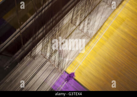 June 15, 2016 - Dhaka, Bangladesh - Colored silk threads on a handloom for making Banarasi sareesi at Mirpur Banarasi Palli, in Dhaka, Bangladesh. Business in Mirpur Banarasi Palli, a market place well-known for different kinds of traditional Banarasi Sarees in Bangladesh, is facing tough times. People, who used to go there to purchase the famous Banarasi sarees, are increasingly opting for trendy Indian sarees. The popularity of these custom-made sarees is losing its charm as colorful Indian chic sarees are more in demand among local buyers. The Benarasi saree, whose history dates back to the Stock Photo