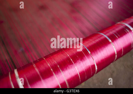 June 15, 2016 - Dhaka, Bangladesh - Colored silk threads on a handloom for making Banarasi sareesi at Mirpur Banarasi Palli, in Dhaka, Bangladesh. Business in Mirpur Banarasi Palli, a market place well-known for different kinds of traditional Banarasi Sarees in Bangladesh, is facing tough times. People, who used to go there to purchase the famous Banarasi sarees, are increasingly opting for trendy Indian sarees. The popularity of these custom-made sarees is losing its charm as colorful Indian chic sarees are more in demand among local buyers. The Benarasi saree, whose history dates back to the Stock Photo